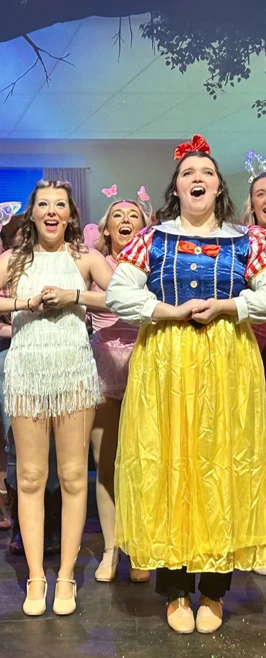 Ensemble cast dressed in colorful costumes, singing joyfully on stage during a musical theatre production. Ensemble cast dressed in colorful costumes, singing joyfully on stage during a musical theatre production.